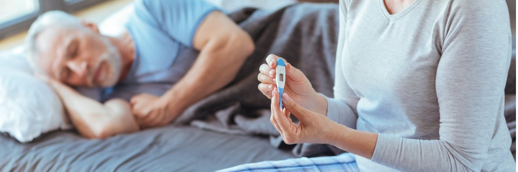Person holding thermometer, man sleeping.