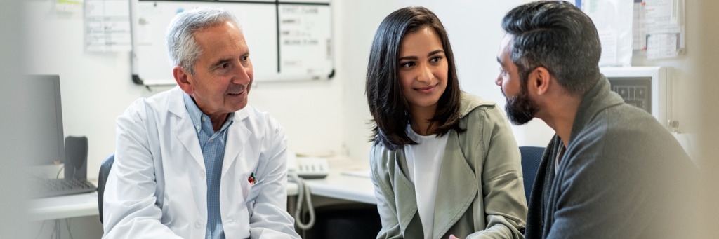 Doctor consulting with couple.