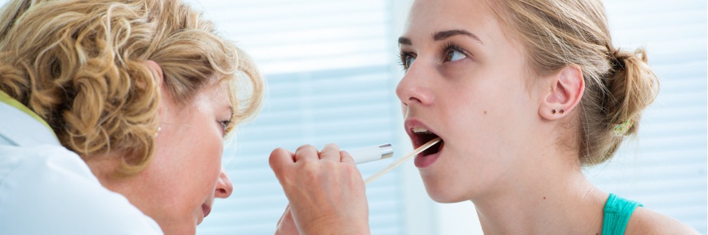 Doctor examining patient's throat.